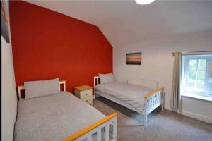 a bedroom with two beds and a window at Dale Cottage 18th Century Country Cottage, 111 Barnston road in Heswall