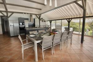 a dining room with a table and chairs and a kitchen at Cœur de Diams in Le Diamant +17 photos