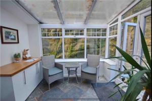 a kitchen with a table and chairs and windows at Dale Cottage 18th Century Country Cottage, 111 Barnston road in Heswall +10 photos