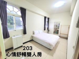 a bedroom with a white bed and a window at Zhen Mei Lu Villa in Puli