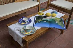 a table with a book and cups and saucers at Casa Vacanze Bouganvillea in Cetara