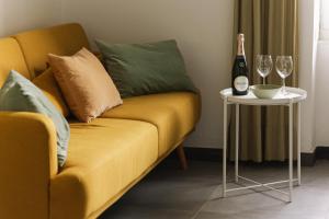 a yellow couch with a bottle of champagne and a side table at Cà de Mâ - Sea Front Suite in Genoa