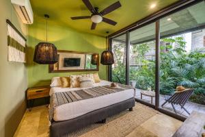 a bedroom with a bed and a green wall at Divine 2BR Tulum on Cenote Gym in Tulum +57 photos