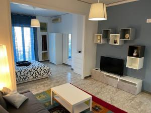 a living room with a bed and a television at Balcony House in Naples