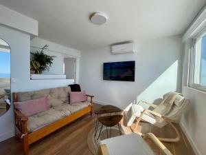 ein Wohnzimmer mit einem Sofa und Stühlen in der Unterkunft Apartamento Calma Carihuela Beach - 10 metros de la playa in Torremolinos