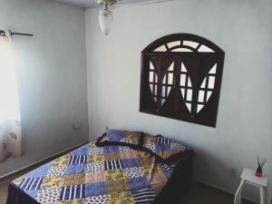 a bedroom with a bed with a quilt on it at casa Amarela in Tamoios