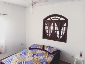 a bedroom with a bed with a quilt on it at casa Amarela in Tamoios