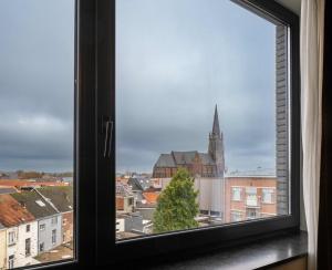 a window with a view of a church at Tower Hotel Aalst in Aalst