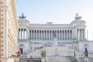 a large building with flags in front of it at Amazing Vista Piazza Venezia in Rome