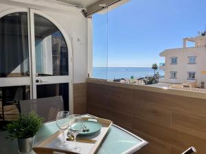 einen Tisch mit Weingläsern und Meerblick in der Unterkunft Apartamento Calma Carihuela Beach - 10 metros de la playa in Torremolinos