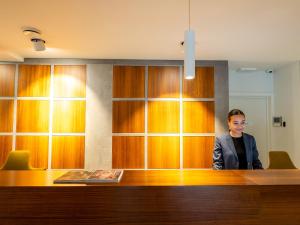 a man is standing behind a desk in a office at Tower Hotel Aalst in Aalst