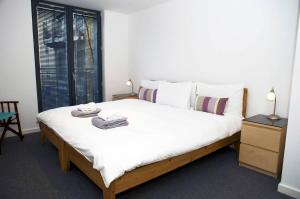a bedroom with a large white bed with towels on it at ALTIDO Inviting flat with parking in Canonmills in Edinburgh