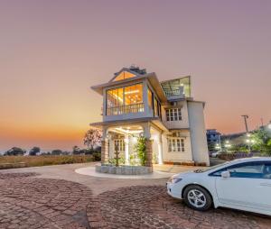 a white car parked in front of a house at Silver Galaxy Resort in Panchgani