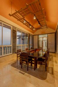 a dining room with a table and chairs and windows at Silver Galaxy Resort in Panchgani
