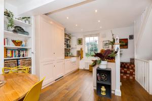 a kitchen and dining room with a table and a stove at Amazing 3-Storey 2BR House, Patio, 5 min Limehouse in London