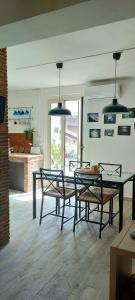 uma sala de jantar com mesa, cadeiras e luzes em L'attico di Rosetta em Catânia