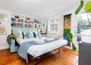 a bedroom with a bed and a book shelf at Amazing 3-Storey 2BR House, Patio, 5 min Limehouse in London