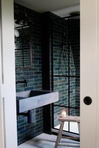a bathroom with a sink with a candle and a stool at Wilder Retreats - A Frame Cabins in Haverfordwest