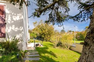 eine Treppe, die zu einem Haus mit einem Baum führt in der Unterkunft La Chevallerie in Saint-Christophe-du-Bois