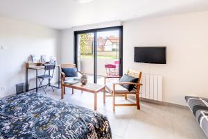 Schlafzimmer mit einem Bett, einem TV und einem Schreibtisch in der Unterkunft La Chevallerie in Saint-Christophe-du-Bois