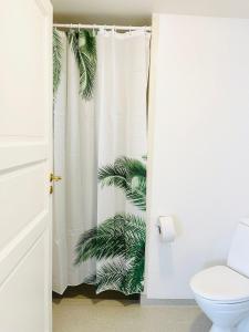 baño con cortina de ducha y planta en Scandinavian Apartment Hotel - Sønderbro - Central 2 room apartment, en Horsens