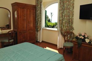 a bedroom with a bed and a window and a desk at Villa Irlanda Grand Hotel in Gaeta
