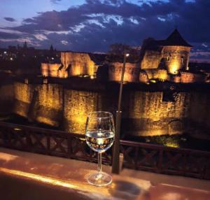 um copo de vinho sentado numa saliência em frente a um castelo em Apartment Rezidence em Suceava