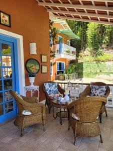 patio z wiklinowymi krzesłami i stołem w obiekcie La Belle Provence w mieście Itaipava