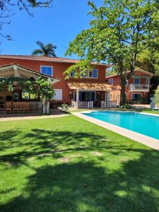 una vista exterior de una casa con piscina en La Belle Provence, en Itaipava