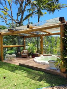 a wooden pergola with a hot tub on a deck at La Belle Provence in Itaipava