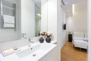 a white bathroom with a sink and a mirror at Amazing Vista Piazza Venezia in Rome