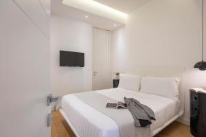 a white bedroom with a bed and a tv on a wall at Amazing Vista Piazza Venezia in Rome