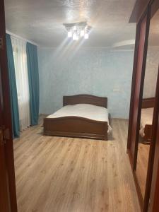 sypialnia z łóżkiem i drewnianą podłogą w obiekcie Домик для гриль и отдыха Телецентр w Kiszyniowie