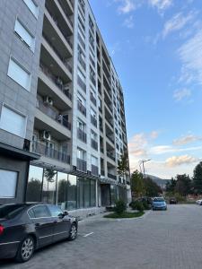 auf einem Parkplatz vor einem Gebäude geparkt in der Unterkunft Skyline Apartment 1 in Peja