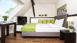 a bedroom with a large bed and a television at Hotel Küstenklang - FREE Parking by ANS in Carolinensiel