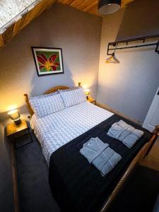 a bedroom with a bed with two towels on it at Glenariff Forest Hideaway in Glenariff