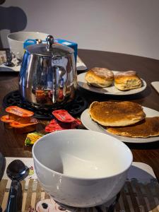 a table with plates of biscuits and a tea kettle at Glenariff Forest Hideaway in Glenariff