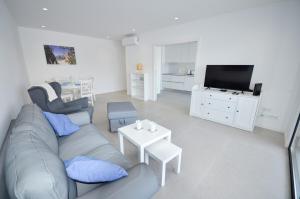 ein Wohnzimmer mit Sofa und Fernseher in der Unterkunft Blue Horizons, (AT18) 2 Bedroom, Olhos de Agua in Olhos de Água