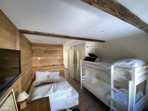 a room with two bunk beds and a flat screen tv at White Paradise in Val dʼIsère