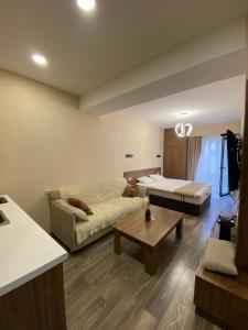 een woonkamer met een bank, een bed en een tafel bij Crystal resort b209 in Bakuriani