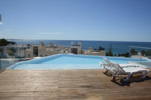ein Swimmingpool mit Tisch und Stühlen auf einem Balkon in der Unterkunft Blue Horizons, (AT18) 2 Bedroom, Olhos de Agua in Olhos de Água