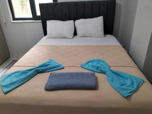 a bed with two towels on top of it at Fatih apart otel in Bostancı