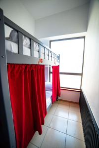 a bedroom with a bunk bed with red curtains at Lunar Hostel in Dubai