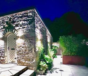 a brick building with a gate and plants at The Old Poolhouse in Beetham +11 photos