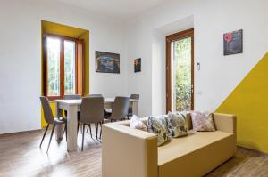 uma sala de estar com um sofá e uma mesa com cadeiras em Casa di Angelo Vibrant Apartment em Perugia