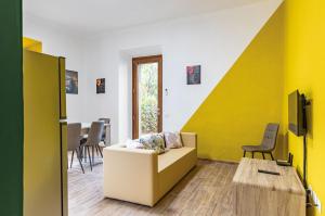 uma sala de estar com um sofá e uma parede amarela em Casa di Angelo Vibrant Apartment em Perugia