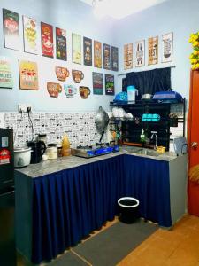 uma cozinha com uma mesa com um balcão azul em LH Alisha Homestay Bandar Utama Gua Musang em Gua Musang