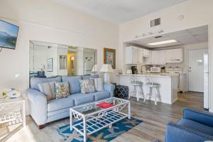 een woonkamer met een blauwe bank en een keuken bij 620 El Matador by Alicia Hollis Realtor Rentals - Open Now in Fort Walton Beach