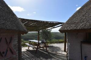 a picnic table on a wooden deck with a roof at La Oca en el Cielo in Treinta y Tres