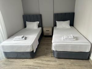 duas camas sentadas uma ao lado da outra num quarto em MARASIUM SUITES em Karamamaras